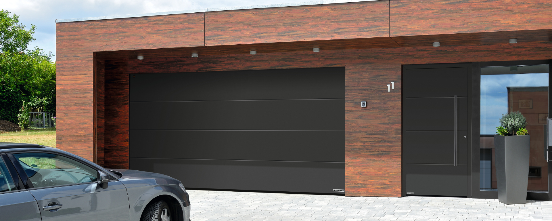 LPU 42 Hörmann Sektionaltor neben abgestimmter Hauseingangstür mit L Sicke Premium RAL 8022